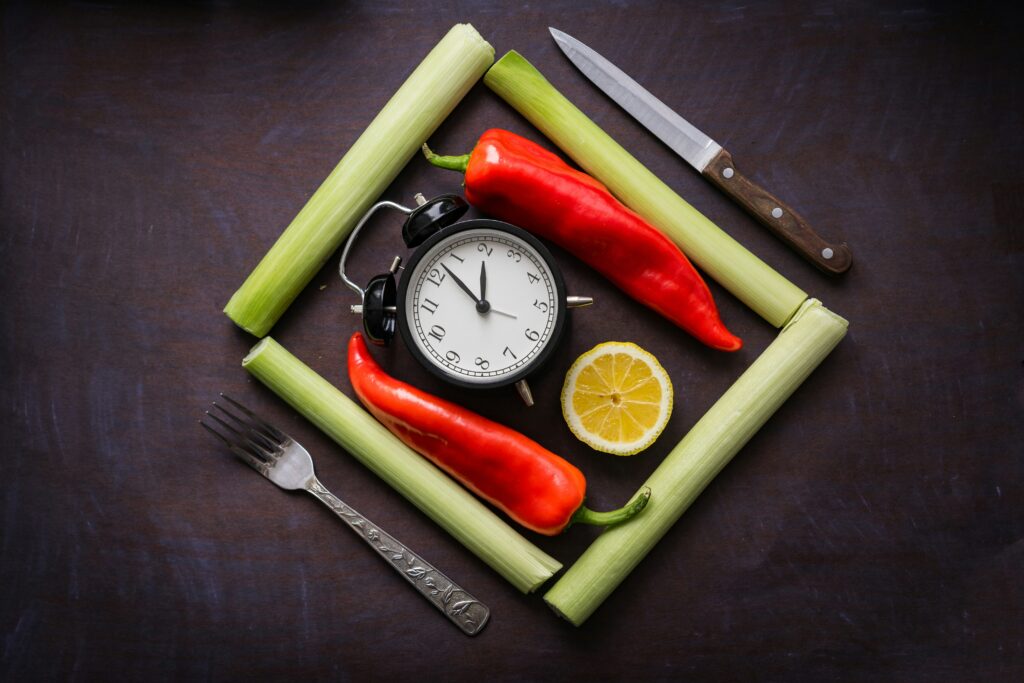 clock surrounded by fresh vegetables representing intermittent fasting for weight loss