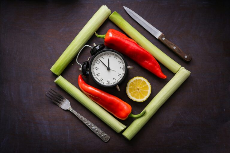 clock surrounded by fresh vegetables representing intermittent fasting for weight loss