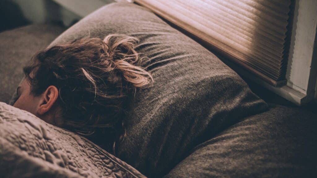 woman sleeping peacefully in bed after taking magnesium for better sleep