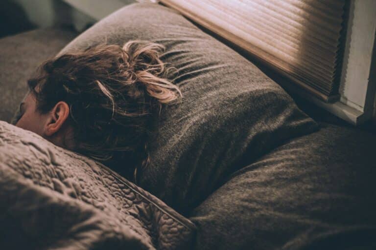 woman sleeping peacefully in bed after taking magnesium for better sleep